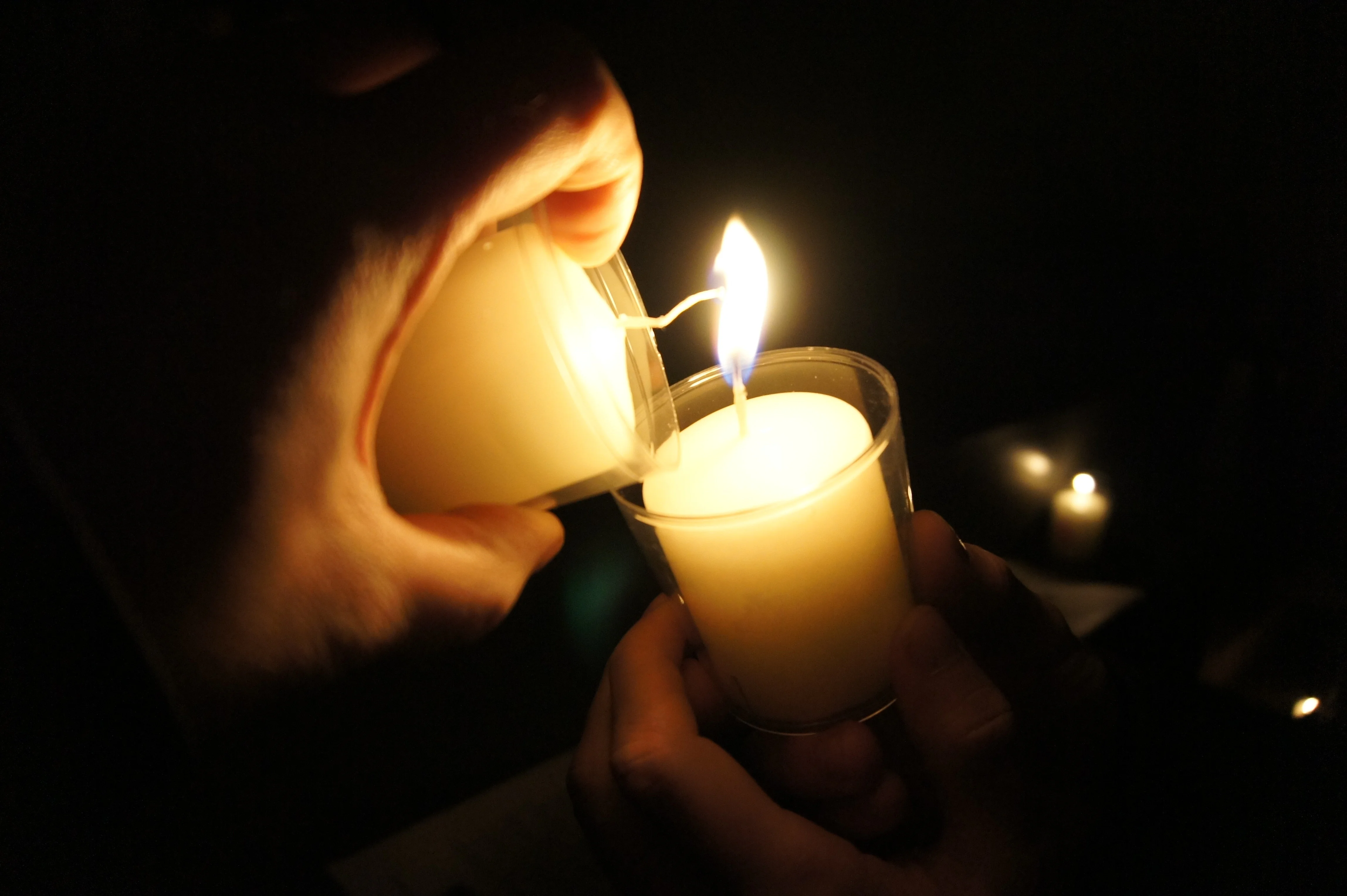 Ein Opferlicht wird an einem anderen angezündet