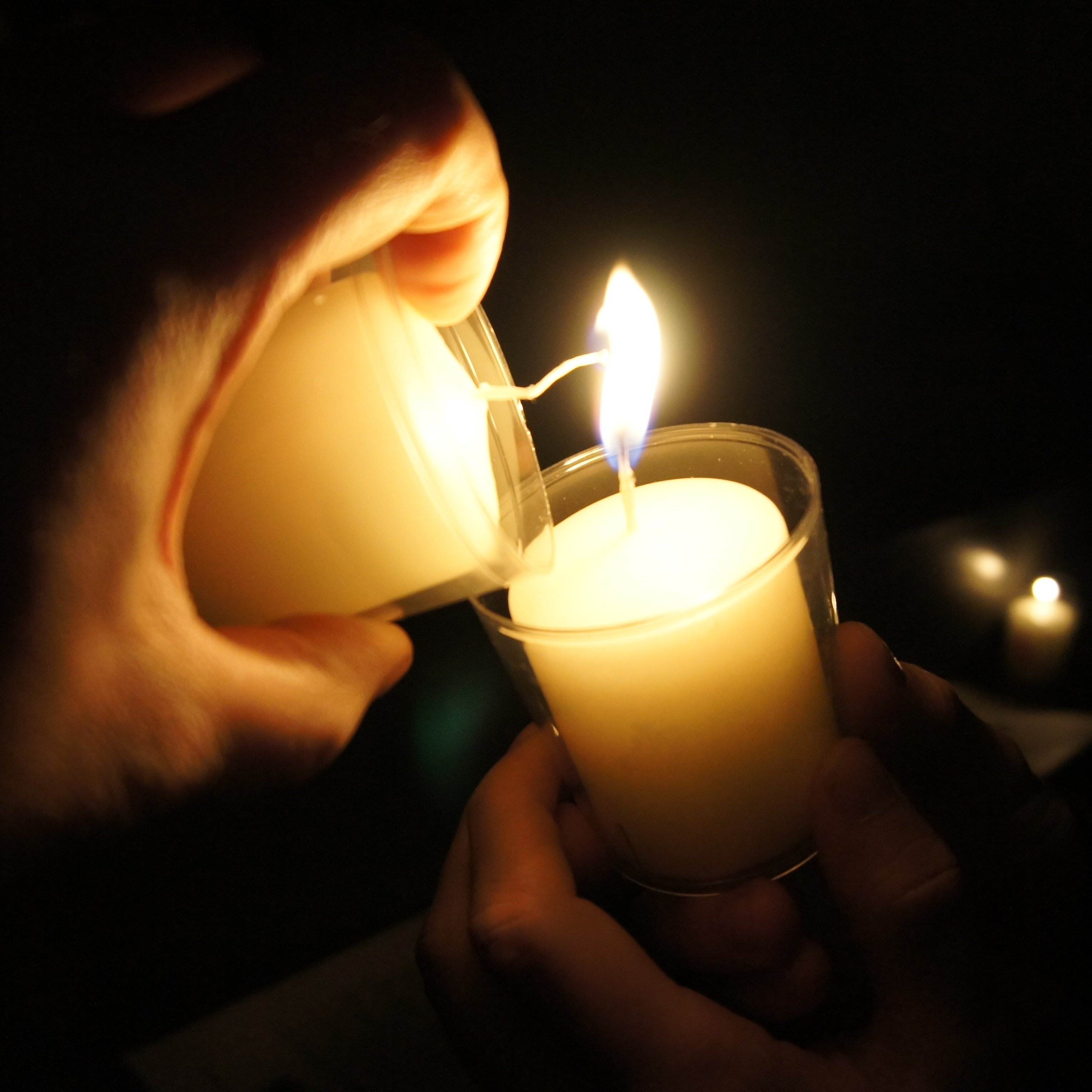 Ein Opferlicht wird an einem anderen angezündet