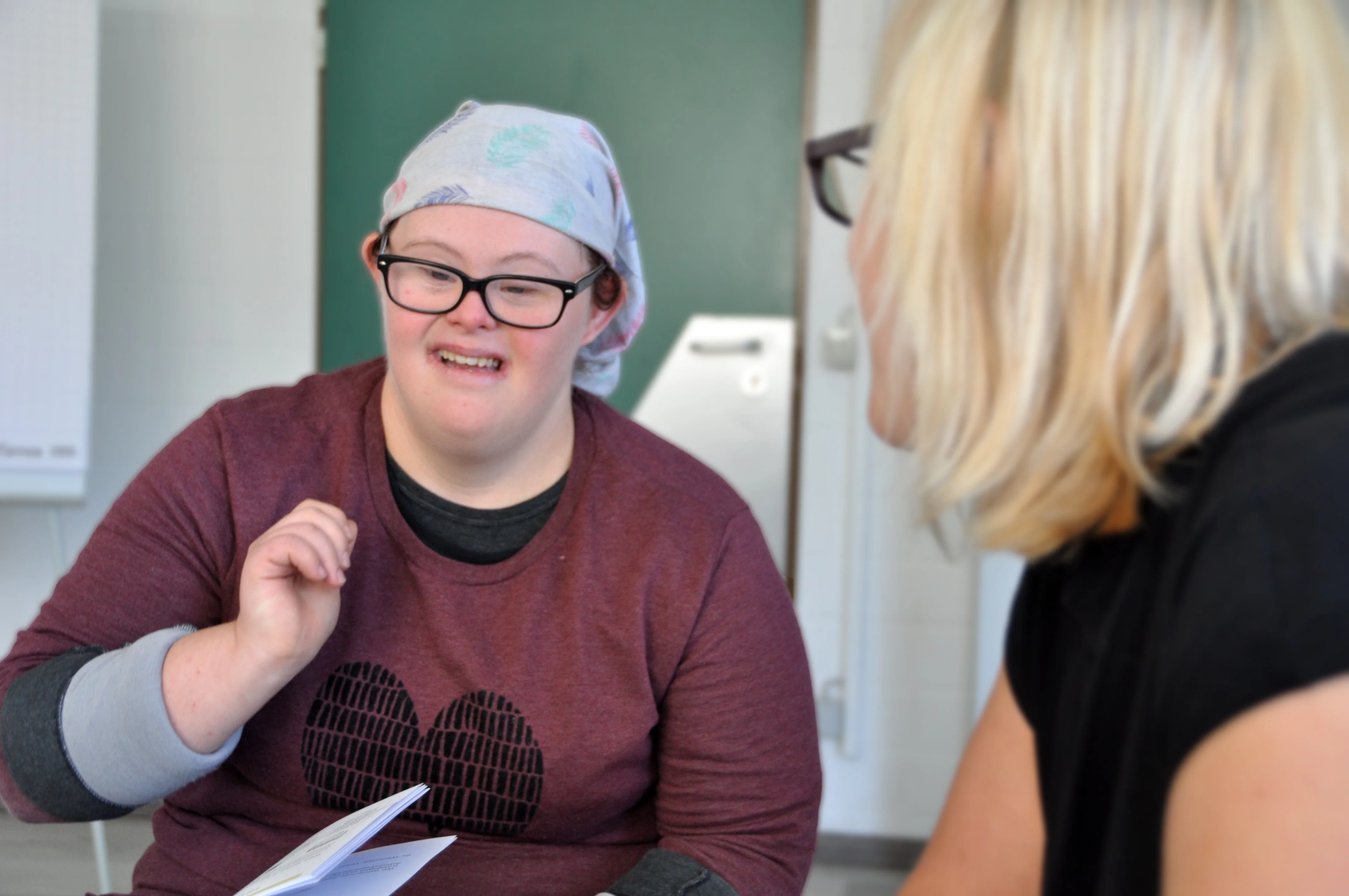 Eine Frau mit Down-Syndrom redet mit einer anderen Frau