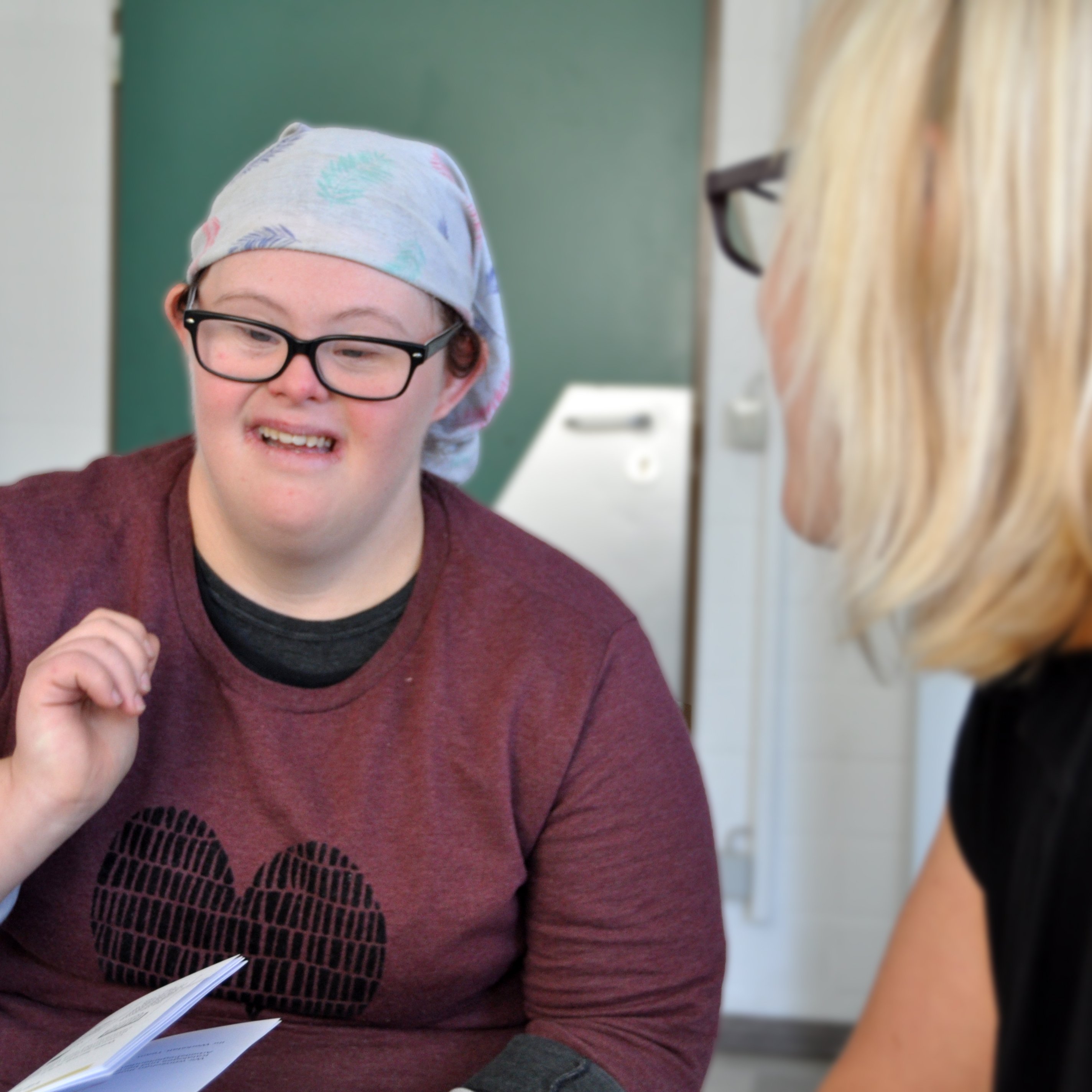 Eine Frau mit Down-Syndrom redet mit einer anderen Frau