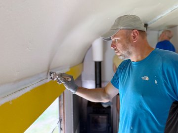 SAP-Mitarbeiter streicht das Innere eines alten Eisenbahnwaggons.