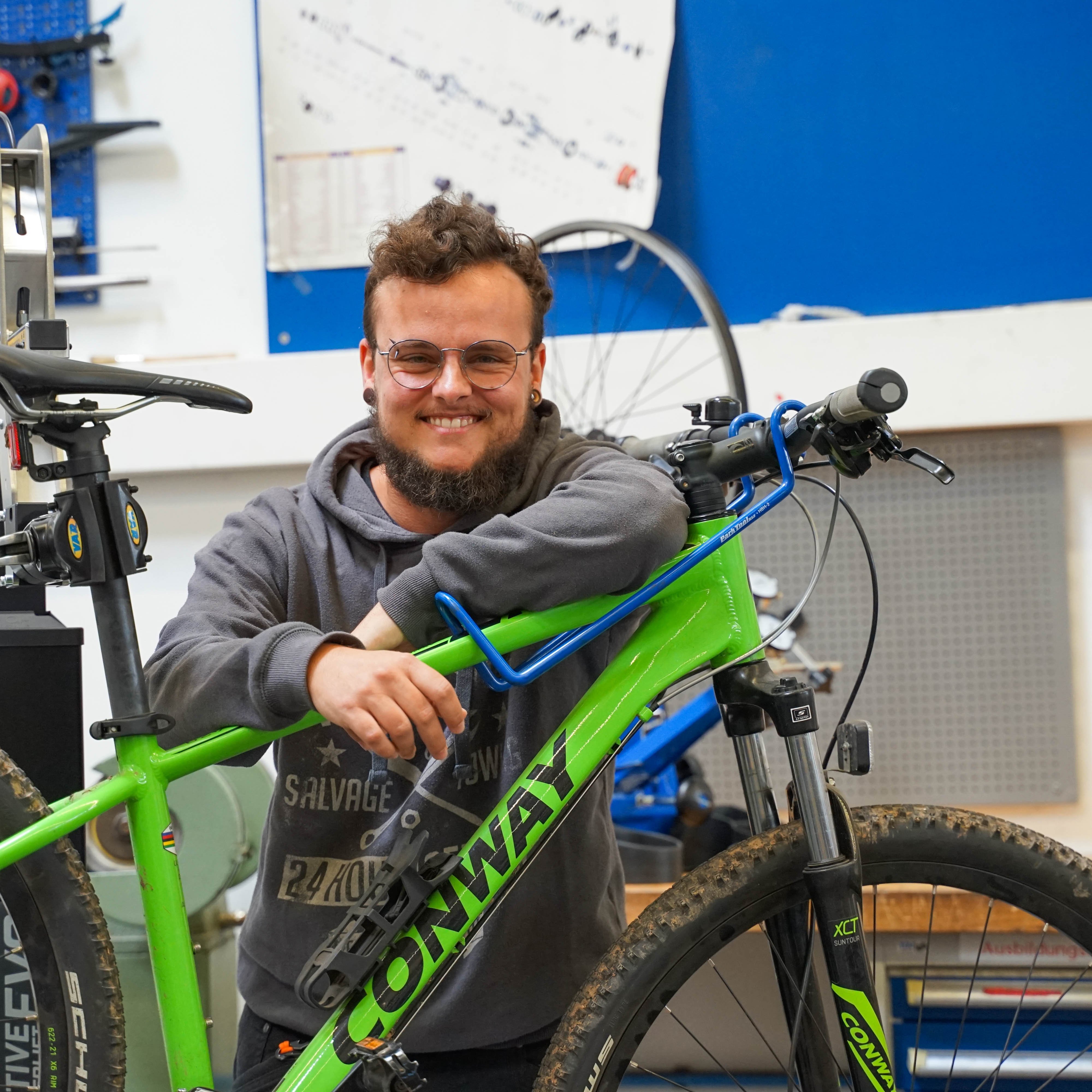 Auszubildender steht hinter einem Fahrrad in der Werkstatt des Berufsbildungswerks Mosbach-Heidelberg