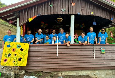 Freiwillige Helfer und  Helferinnen von SAP stehen im Vorraum einer Blockhütte.