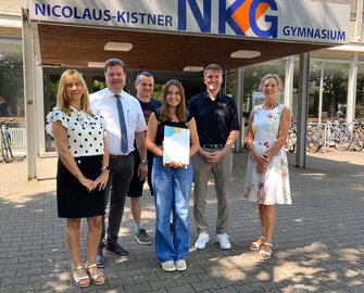 Elaine Haas (Bildmitte) freut sich über den Johannes-Diakonie-Sozialpreis mit von links Elvira Horvath (stellvertretende Schulleitung), Schulleiter Jochen Herkert, Schul-Sozialarbeiter Manuel Zin sowie Johannes-Diakonie-Vorstand Dr. Martin Holler und Ehrenamtskoordinatorin Tanja Bauer.