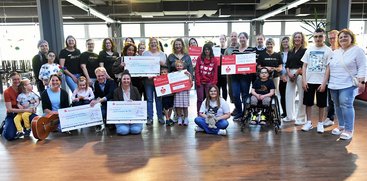 Mitglieder von Inner Wheel und Soroptimist sowie Menschen aus der Johannes-Diakonie posieren bei einerSpendenübergabe im Kultur- und Begegnungszentrum fideljo.