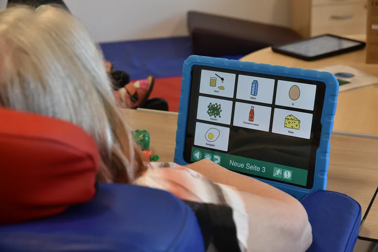 Eine Frau nutzt ein Tablet, um sich zu verständigen.