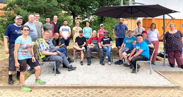 SAP-Mitarbeitende und Menschen aus den Rhein-Neckar-Werkstätten im Garten der Werkstätten