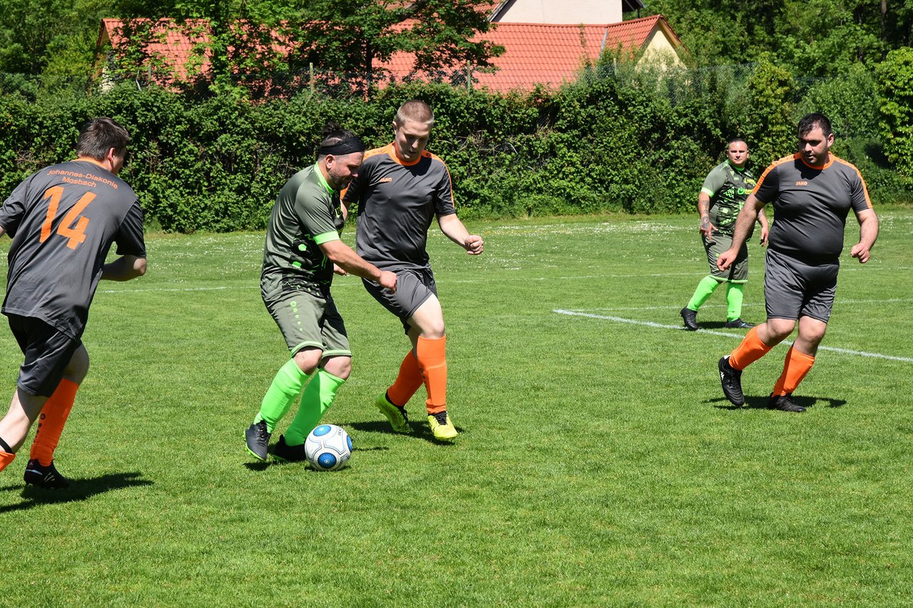 Fußballspieler laufen auf dem Feld. Zwei Spieler führen einen Zweikampf um den Ball.
