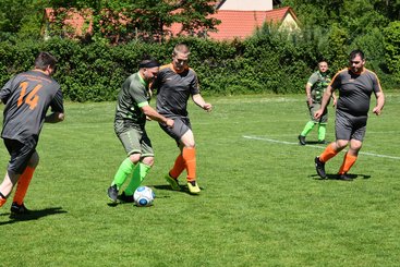 Fußballspieler laufen auf dem Feld. Zwei Spieler führen einen Zweikampf um den Ball.