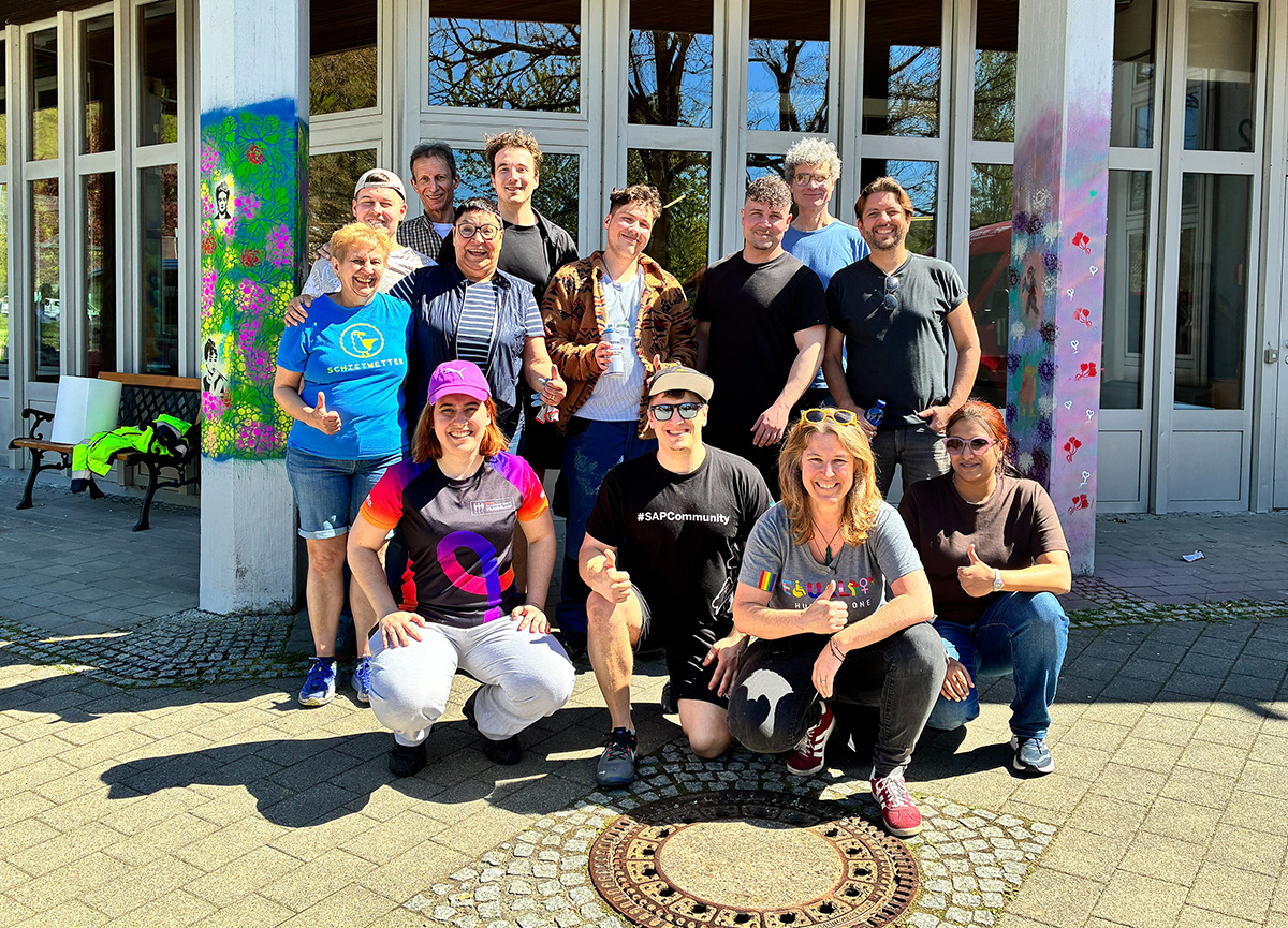 SAP-Team posiert vor der Johannesberg Schule zwischen bunt besprühten Betonsäulen.