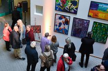 Besucher betrachten Bilder der Ausstellung "Ich WÜRDE gerne..."