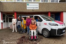Klientinnen und Klienten stehen mit Mitarbeitenden vor der Seniorentagesstätte in Schwarzach