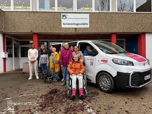 Klientinnen und Klienten stehen mit Mitarbeitenden vor der Seniorentagesstätte in Schwarzach