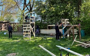 Mitarbeitende von John Deere arbeiten auf der Jugendfarm Schwarzach im Hüttenbaudorf.