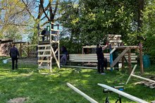 Mitarbeitende von John Deere arbeiten auf der Jugendfarm Schwarzach im Hüttenbaudorf.