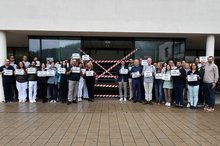 Mitarbeitende der Diakonie-Klinik protestieren vor dem Klinikgebäude.