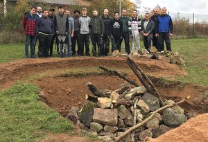 Beschäftigte der Buchener Werkstätten und Auszubildende von Scheuermann +Heilig stehen neben einer Eidechsenburg.