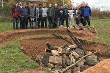 Beschäftigte der Buchener Werkstätten und Auszubildende von Scheuermann +Heilig stehen neben einer Eidechsenburg.