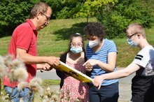 Imkermeister Hans-Jürgen Lohmüller erläutert Schülerinnen und Schülern der Johannesberg Schule die Vorgänge im Bienenstock auf dem Gelände der Johannes-Diakonie.