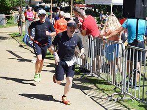 Zwei Männer in schwarzen Triathlonanzügen sprinten hintereinander beim Triathlon in Lorsch ins Ziel.