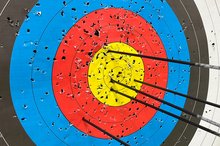 Das Bild zeigt eine Zielscheibe und darin steckende Pfeile.