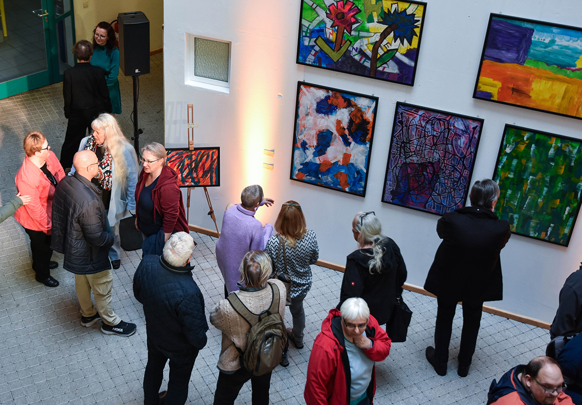 Besucher betrachten Bilder der Ausstellung "Ich WÜRDE gerne..."
